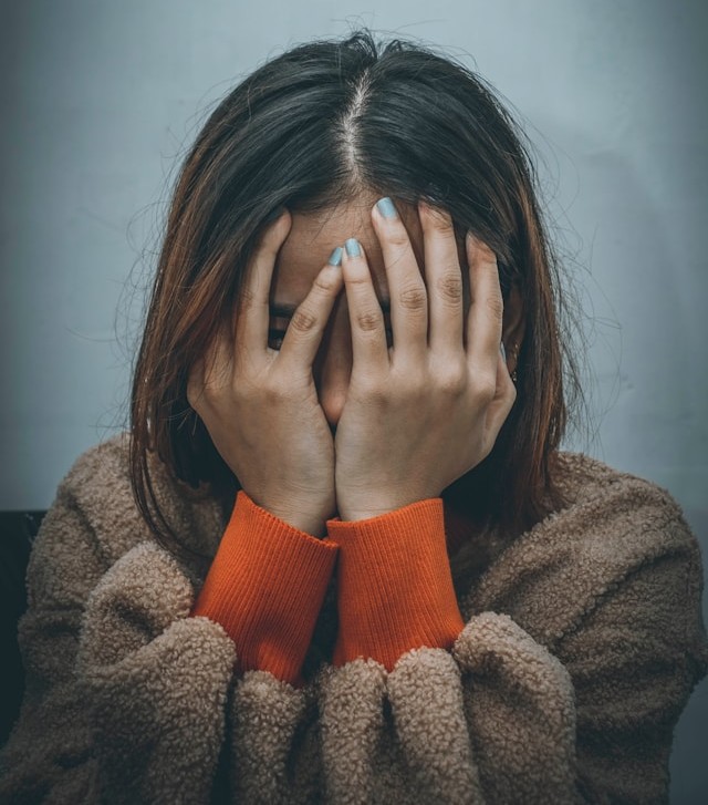 woman covering her face with her hands